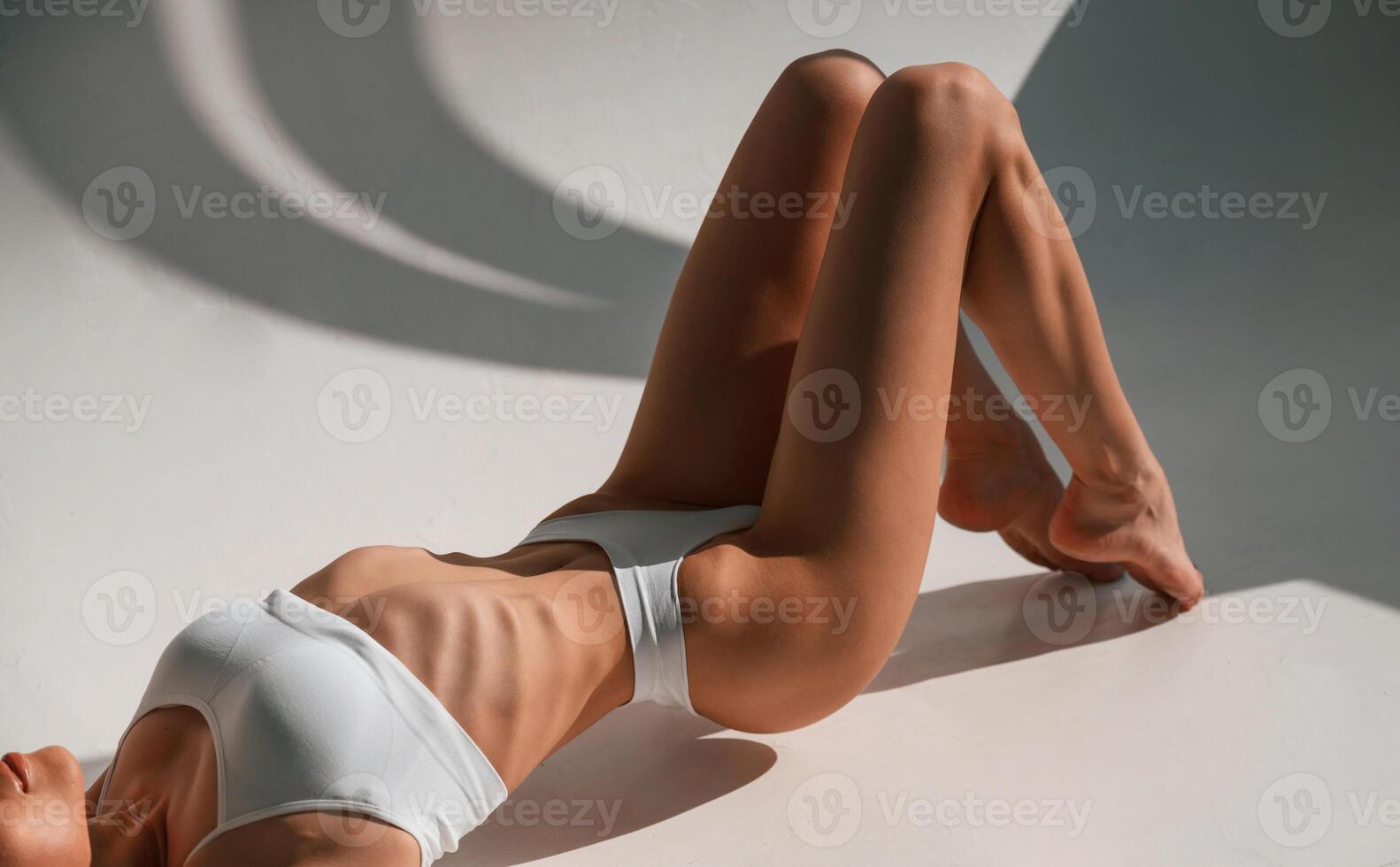 Young,, caucasian woman with slim body shape is indoors in the studio photo