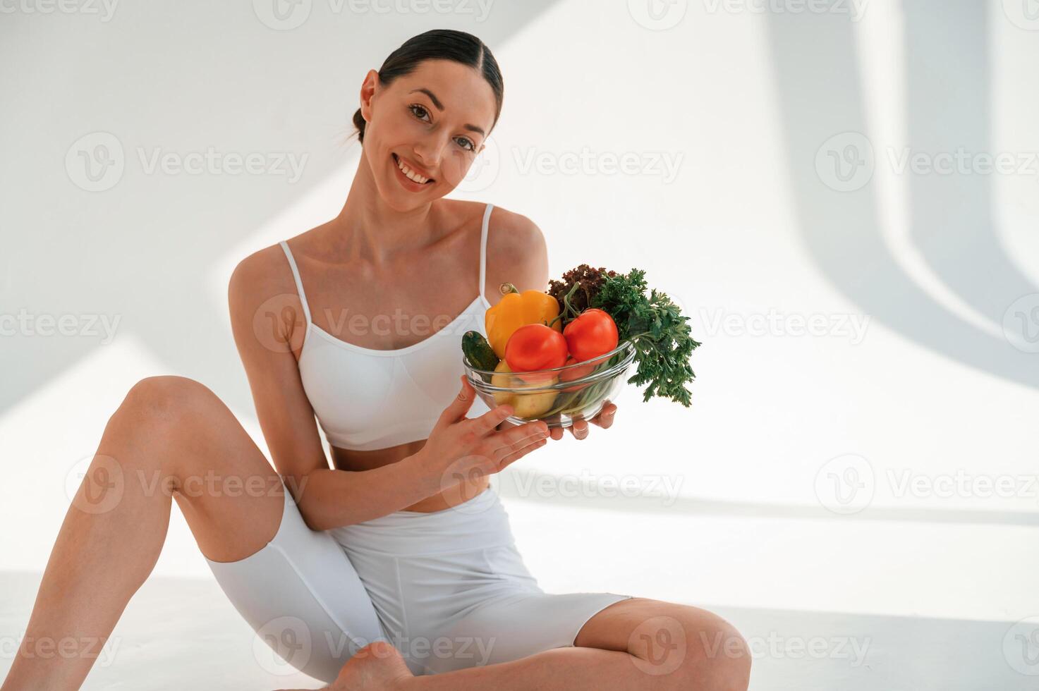 Enjoying ,sunlight, sitting with ,food. Young caucasian woman with slim body shape is indoors in the studio photo