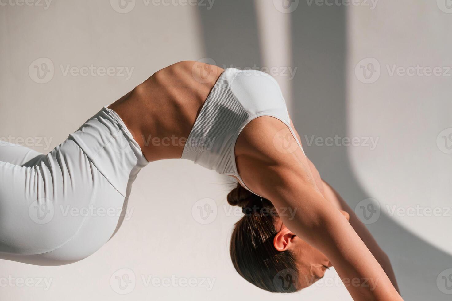 Young caucasian woman ,with slim b,ody shape is indoors in the studio. Fitness exercises photo