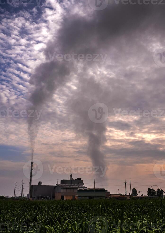 Black Smoke from the boiler stack and the vapor from a cooling tower in the power plant photo