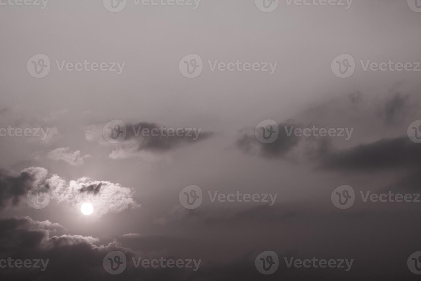 Grey fluffy clouds in the morning sky with sunlight photo