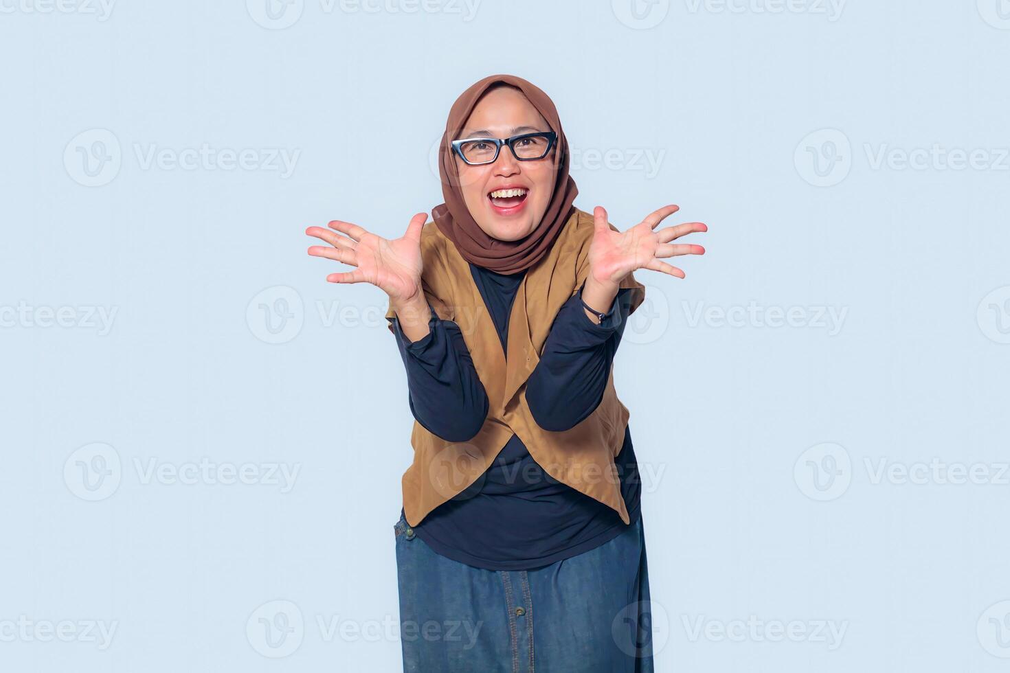A joyful Muslim woman in a hijab showing excitement with open hands photo