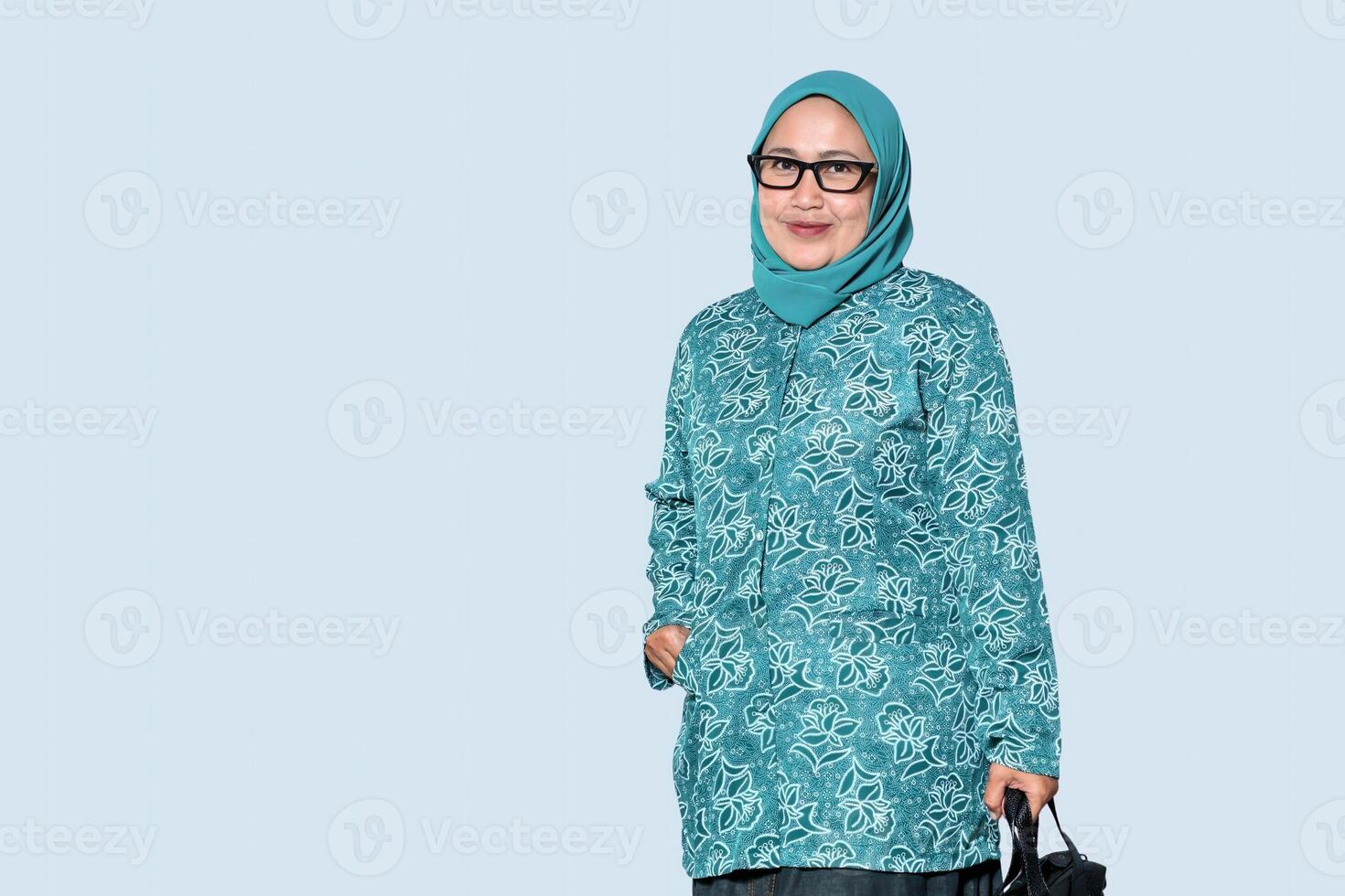A confident Muslim woman wearing glasses and holding a handbag, smiling photo