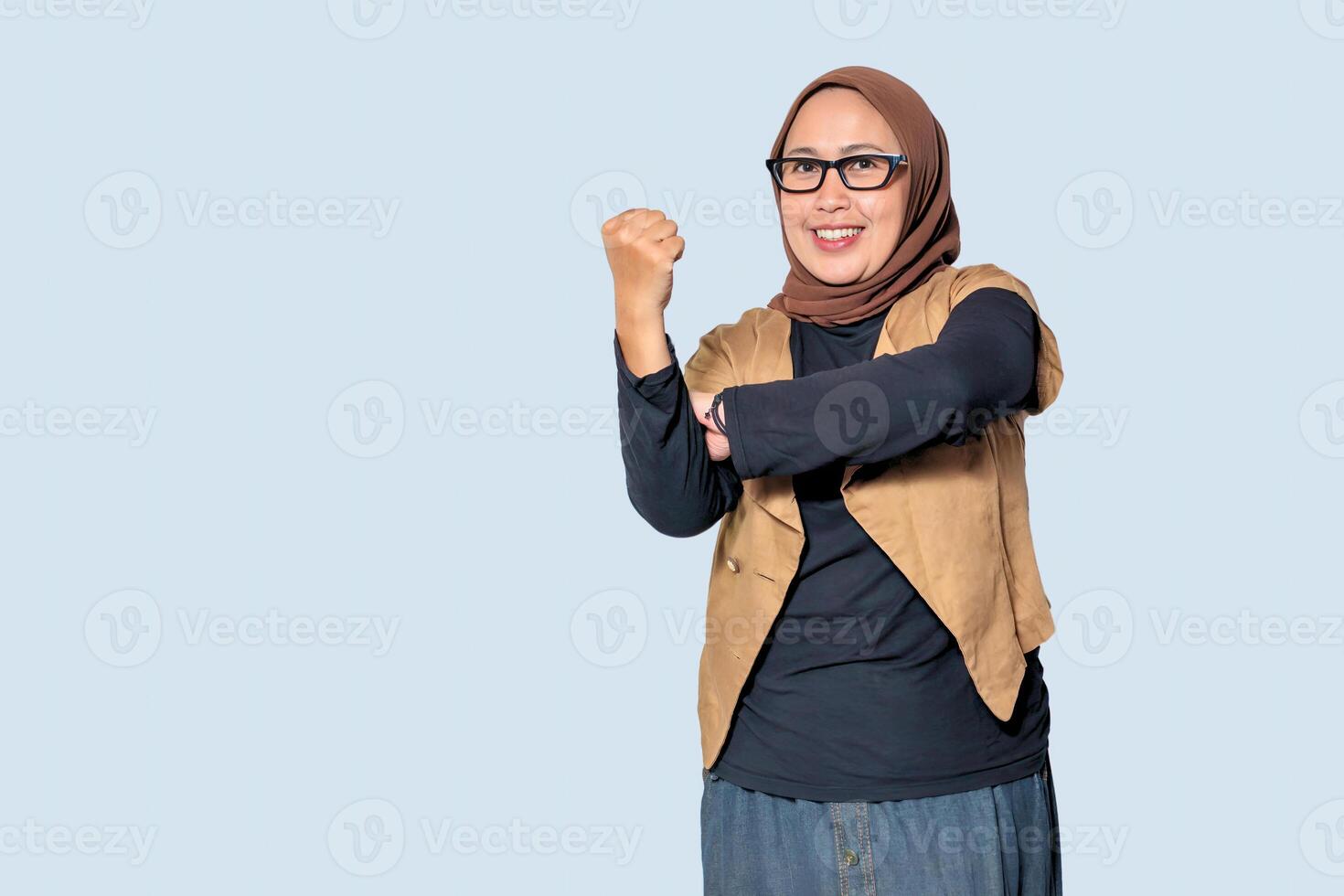 A strong and confident Muslim woman in hijab making a power gesture, symbolizing determination and success photo