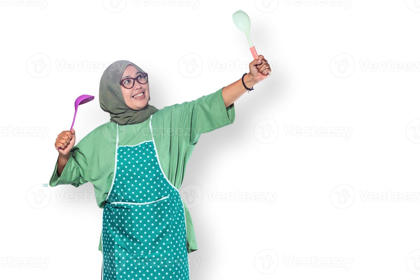 Excited Muslim Woman Cooking with Kitchen Utensils photo