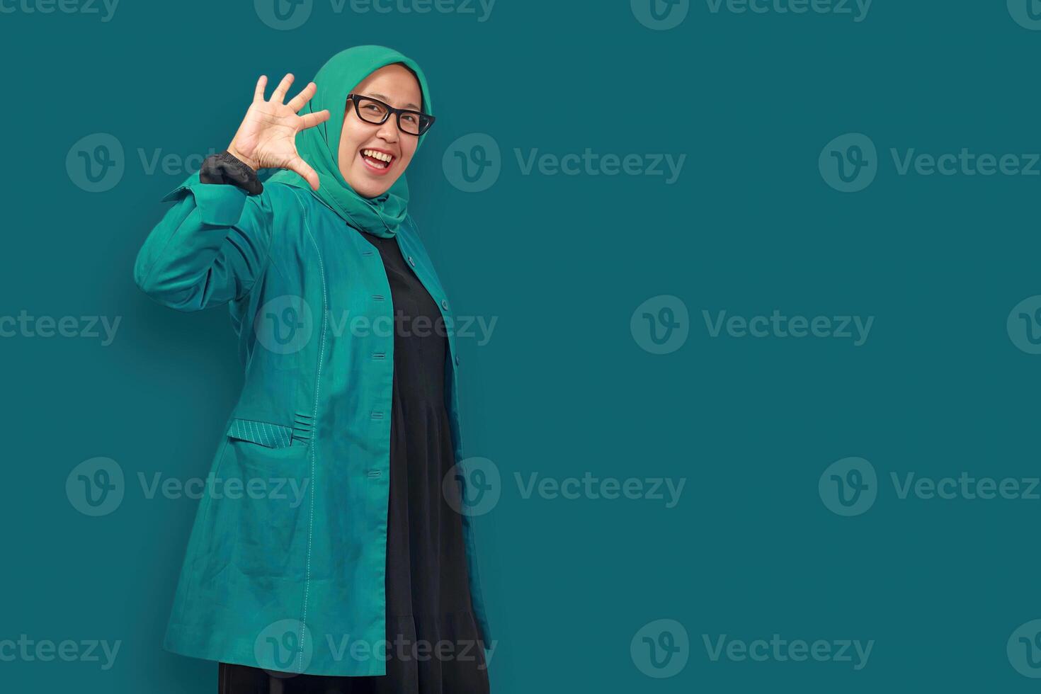 Cheerful Muslim woman waving hand with a warm smile expressing happiness photo