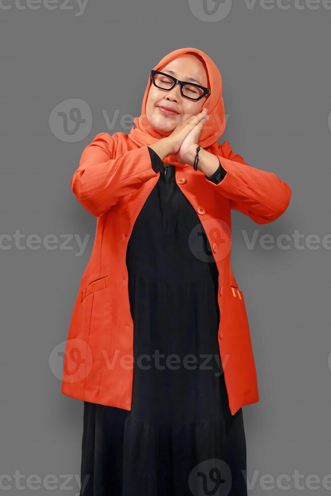 Happy Muslim woman in orange hijab and black dress smiling peacefully in a relaxing pose with a calm expression photo