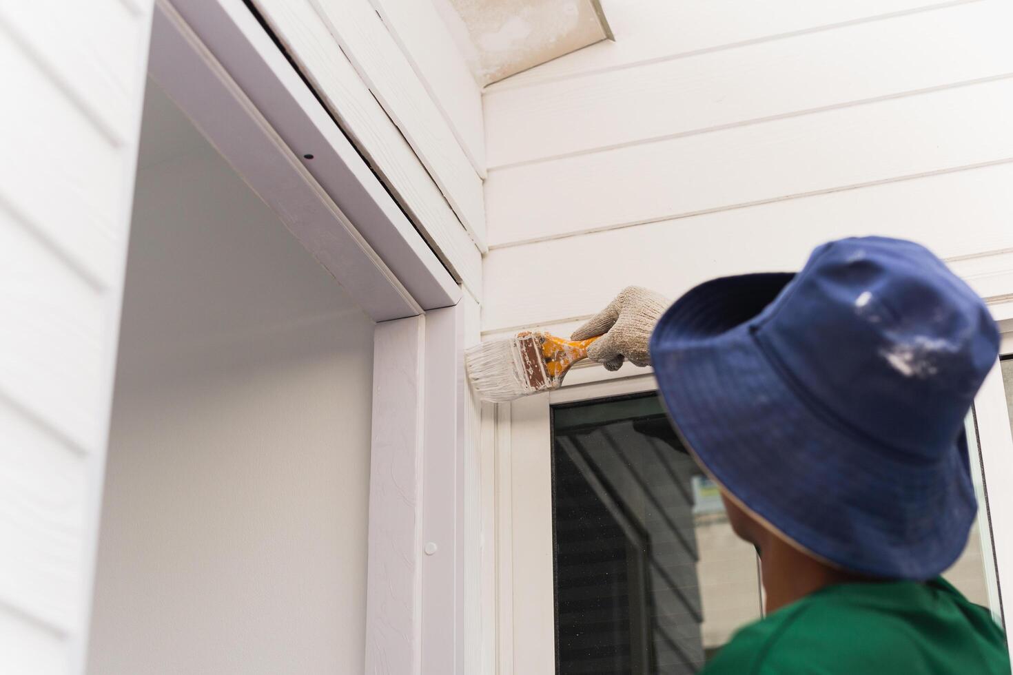 Unidentified painter painting exterior wall for house improvement. photo