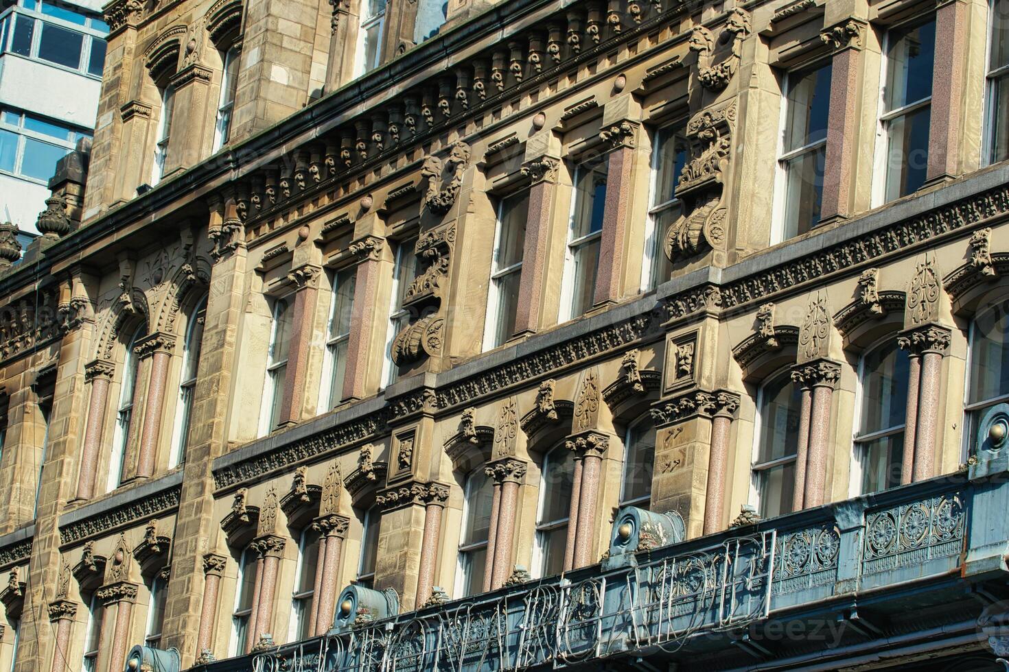 Building Facade with Windows, Ornate Details, and Balcony in Manchester, UK. photo