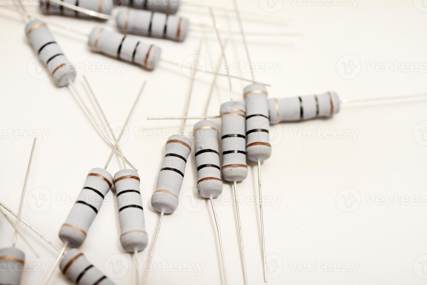 Porcelain resistors displayed against a neutral white surface. Electrical components utilized in tech devices. photo