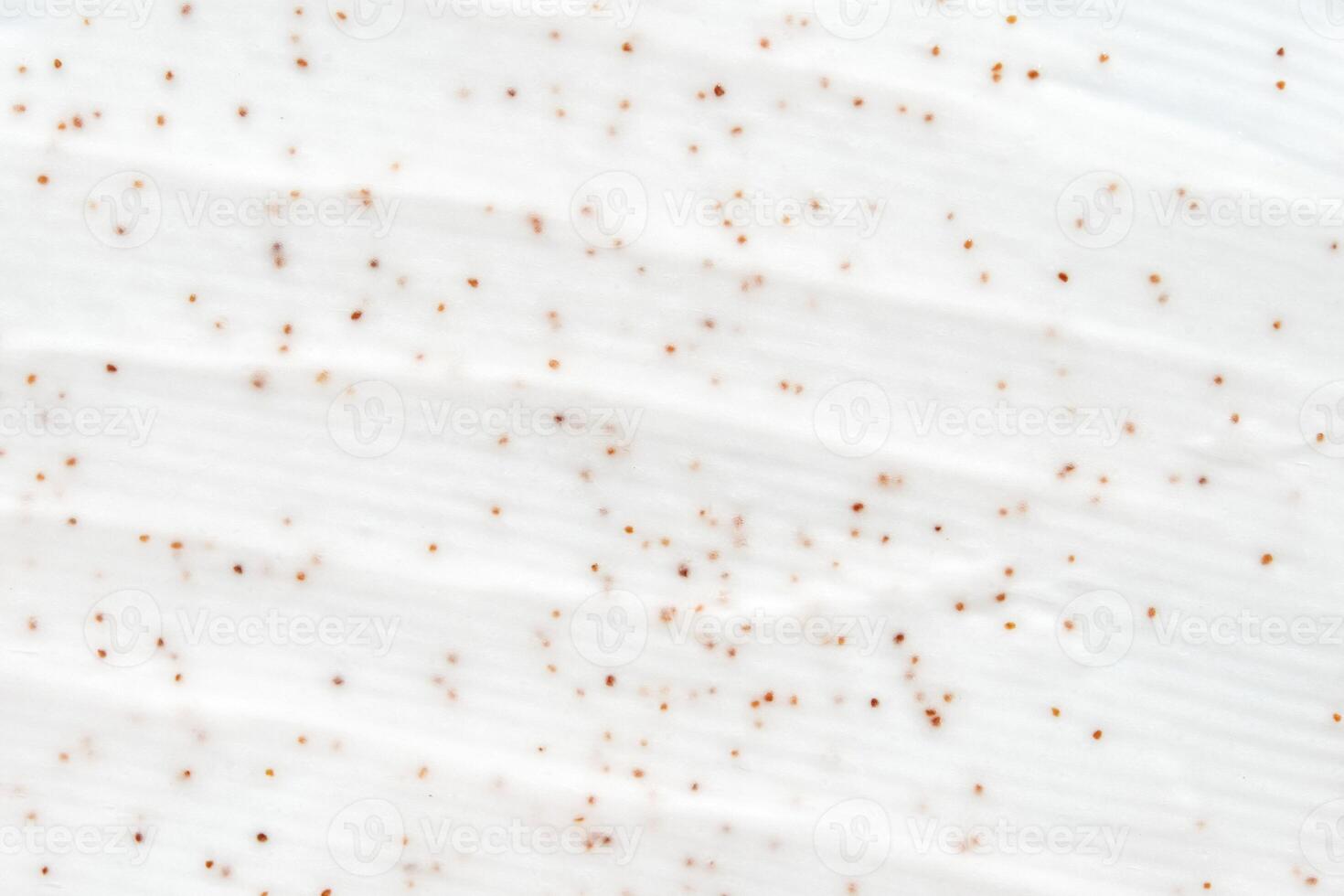 Close up of white cream with exfoliating beads and smooth textured surface. photo