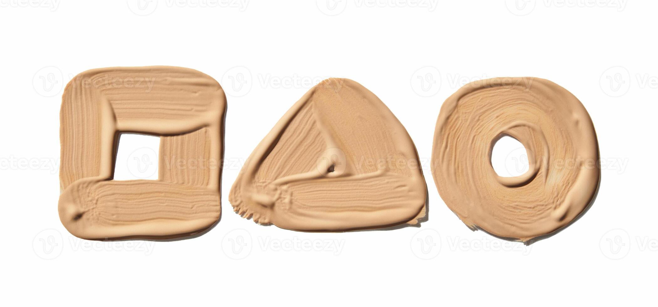 Beige makeup smudges forming square triangle and circle shapes on white background. photo