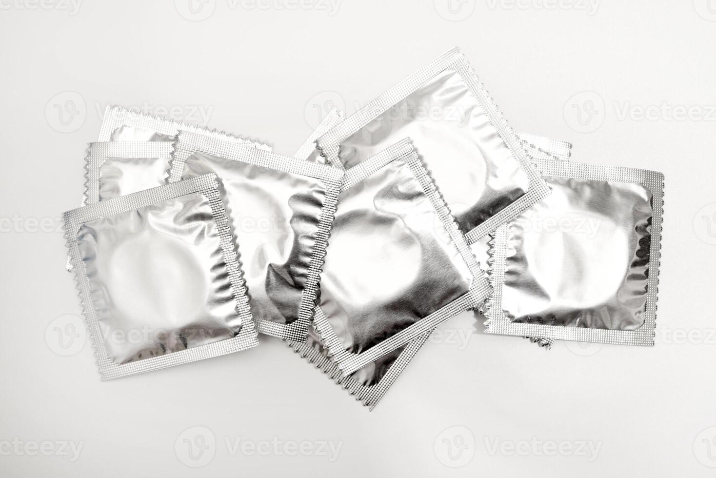 Sparkling prophylactic wrappers on a white base. photo