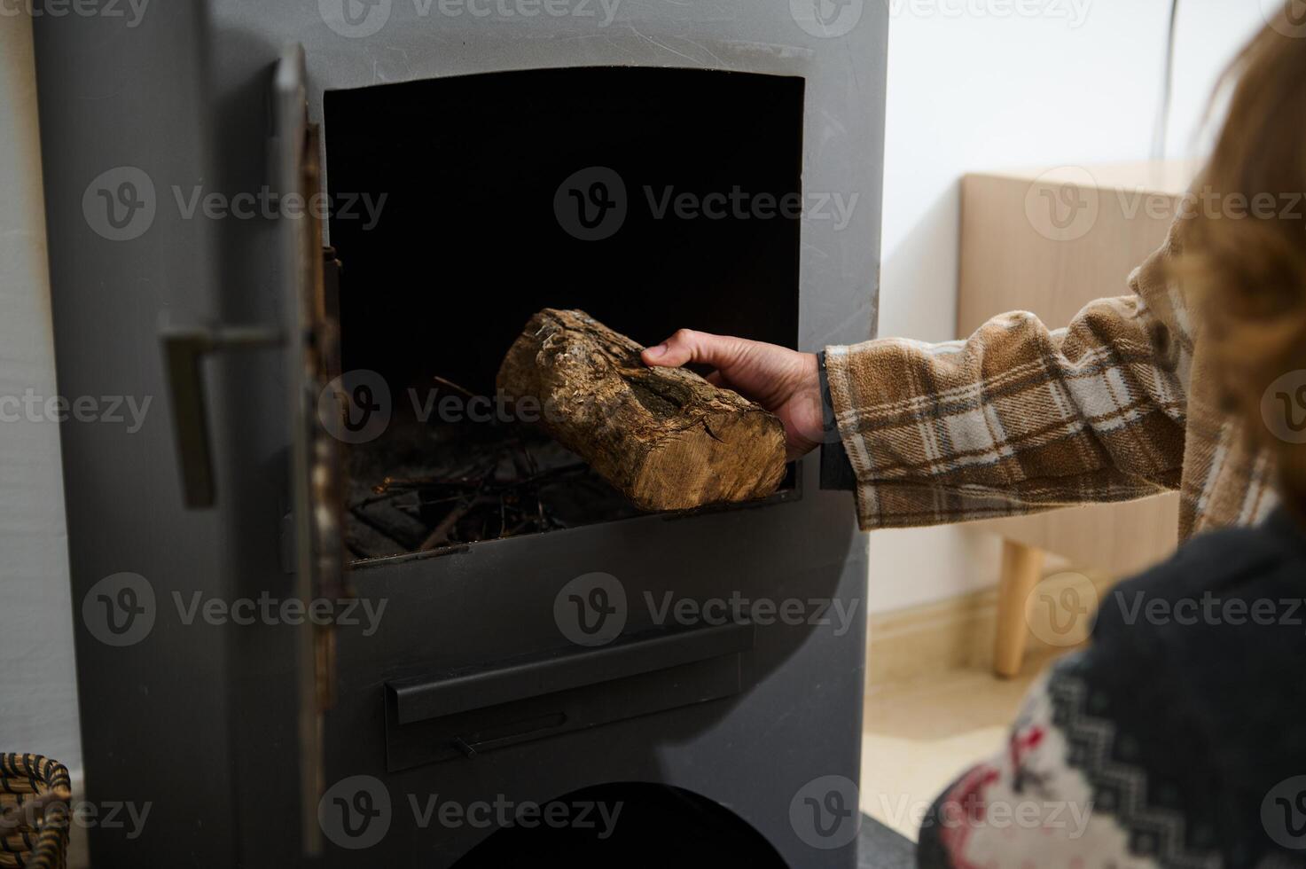 Adding a Log to a Potbelly Stove in a Cozy Home Setting photo