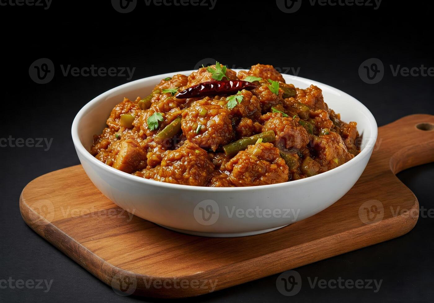 A bowl of curry with vegetables and spices on a wooden board photo