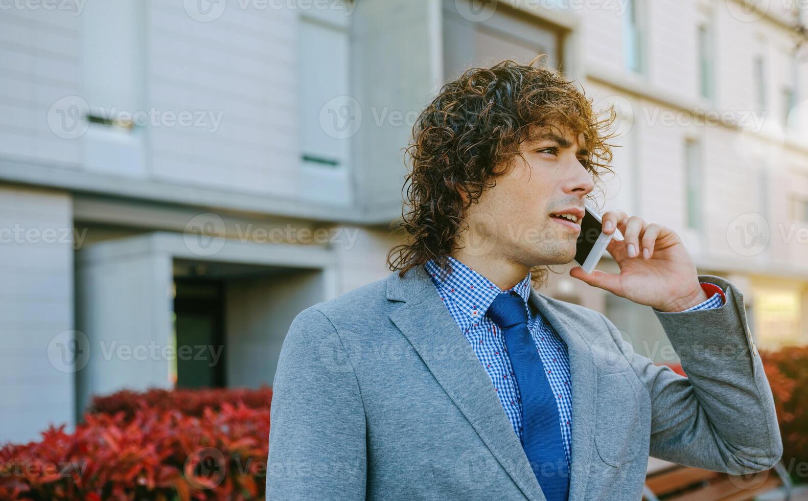 A man in a suit and tie talking on a cell phone photo