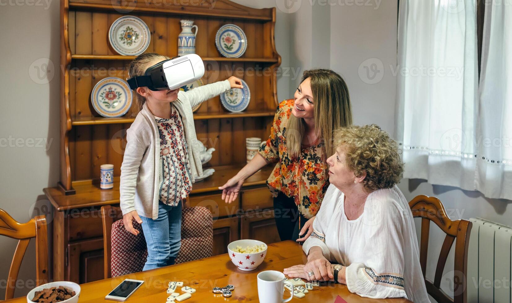 A woman and two children playing with a virtual reality headset photo