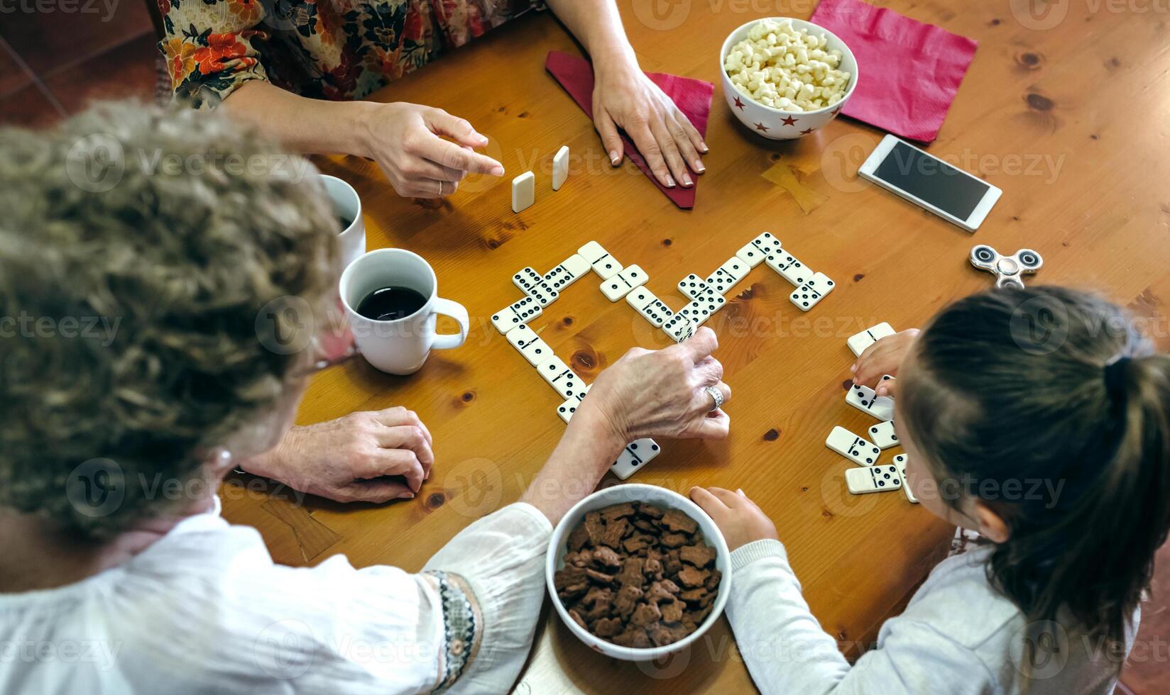 A family playing dominoes at a table photo