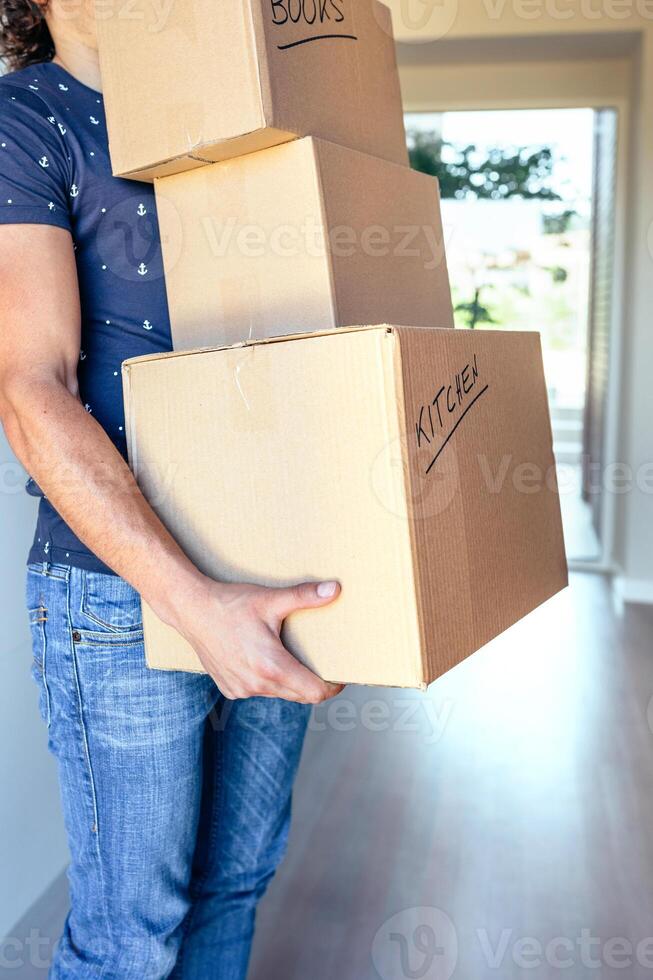 A man carrying a stack of boxes in his hand photo