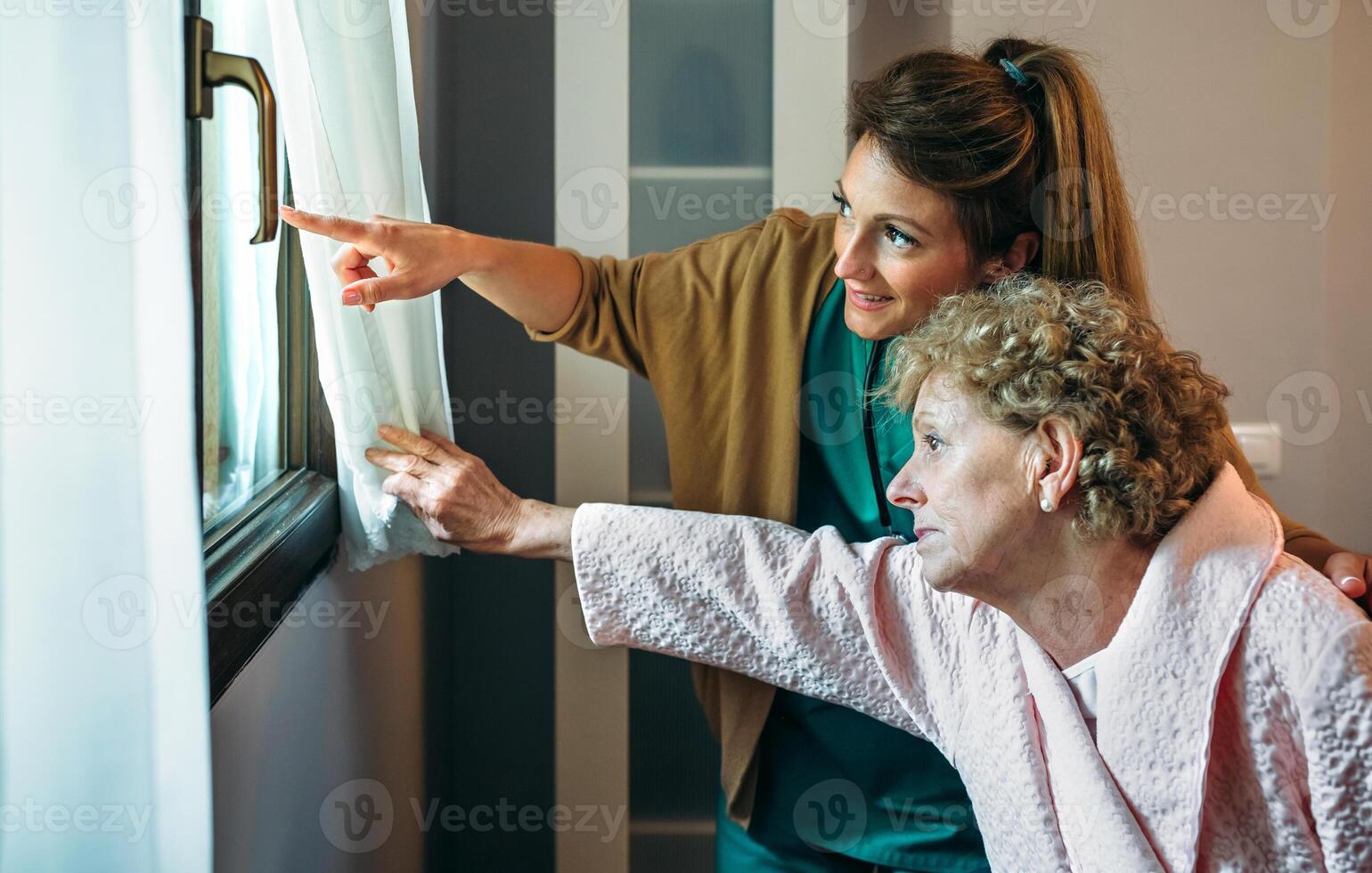 A woman pointing to a curtain in a window photo