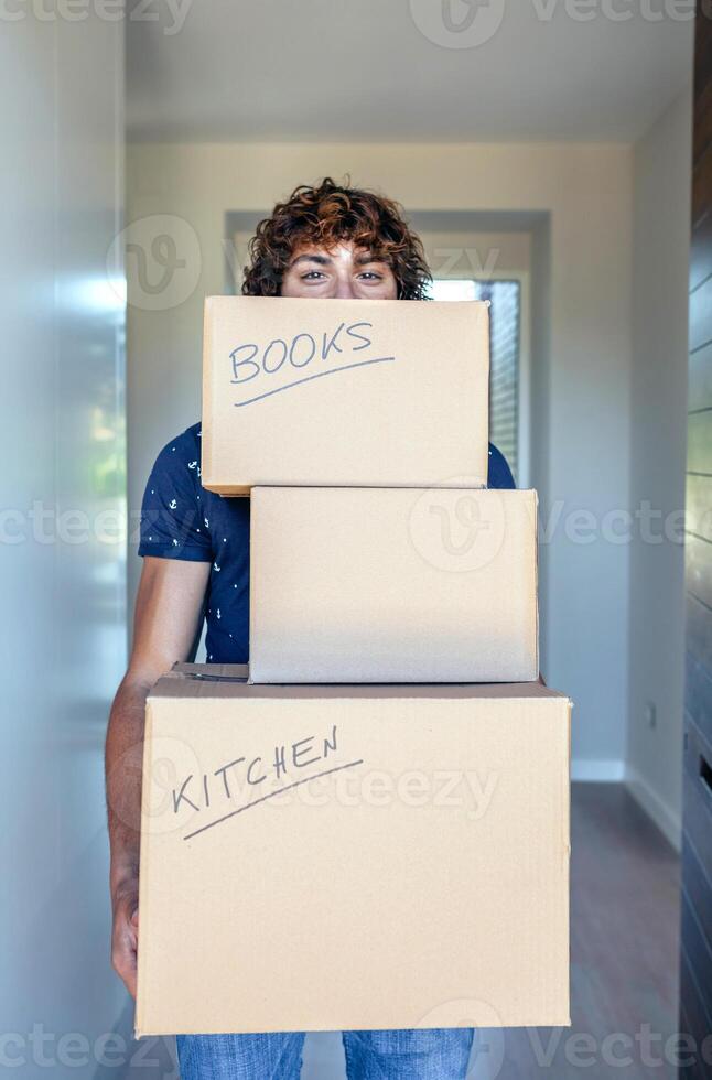 A man holding three boxes with the words books and kitchen written on them photo