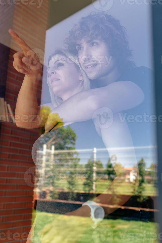 A man and woman are looking at a picture of themselves photo