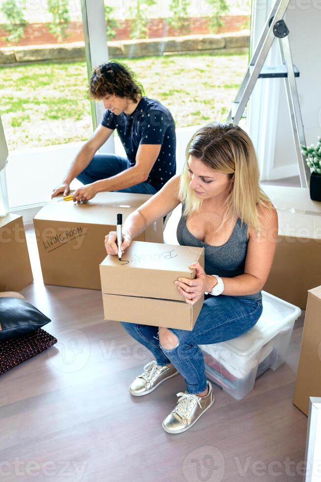 A woman and man are moving boxes into a new home photo