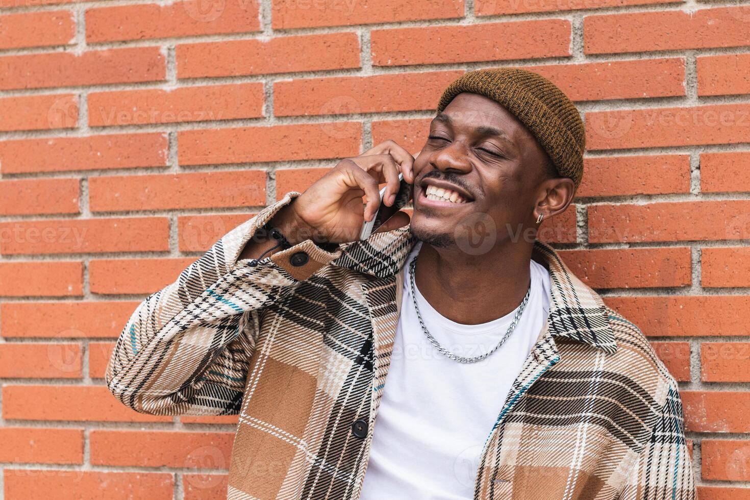 A man is smiling while talking on his cell phone photo