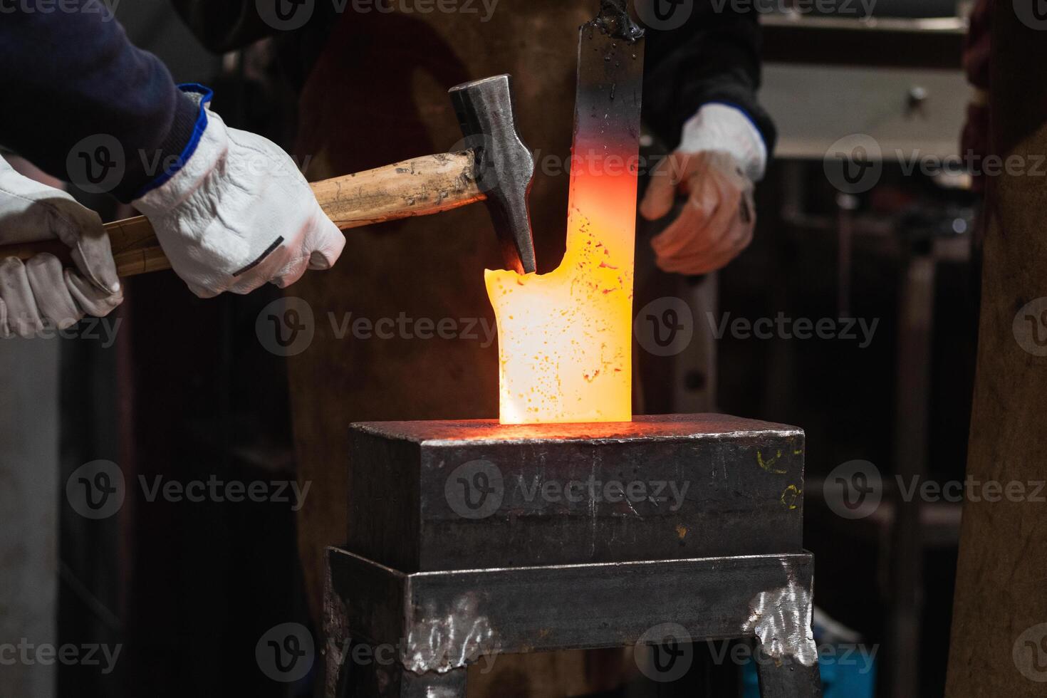 A person is using a hammer to make a piece of metal art. photo