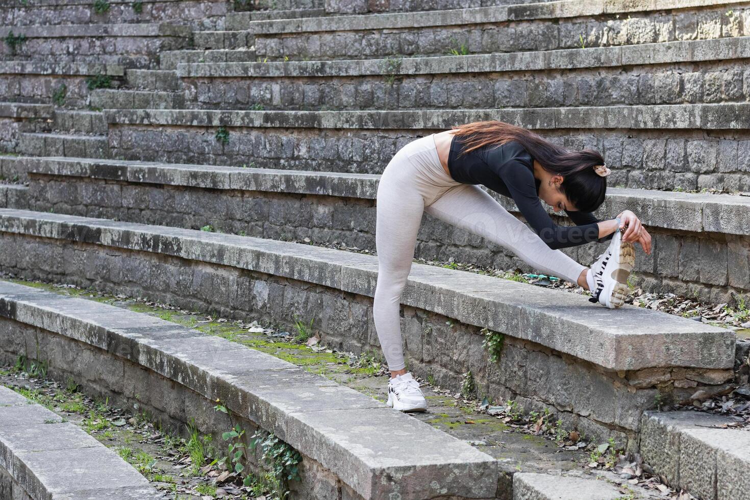 A woman stretching on the steps of an old building photo