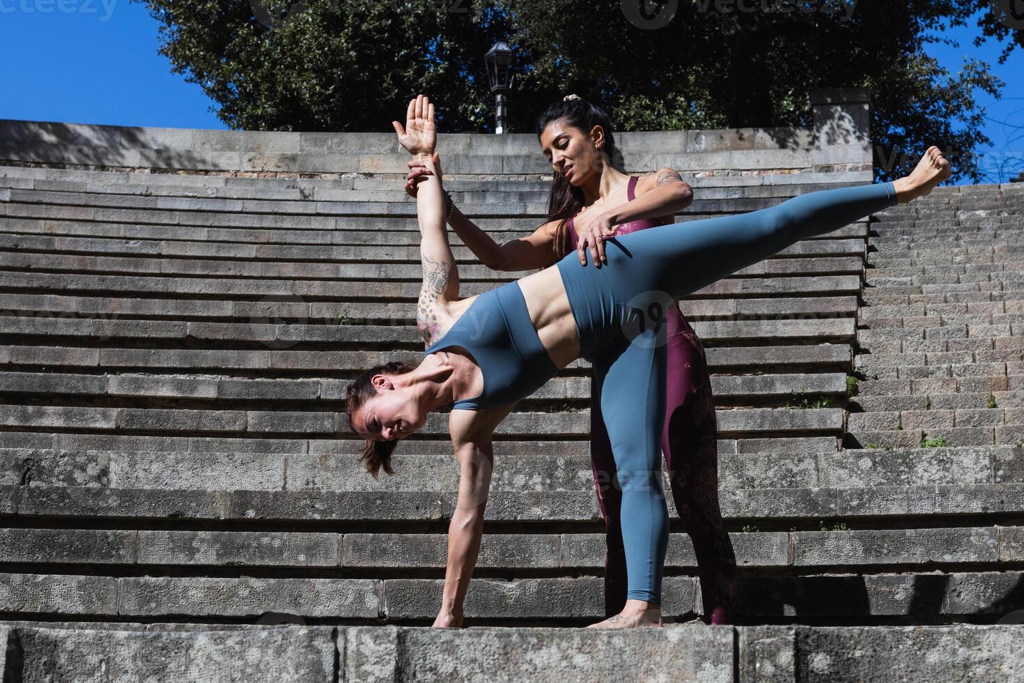 Two women doing yoga on steps photo