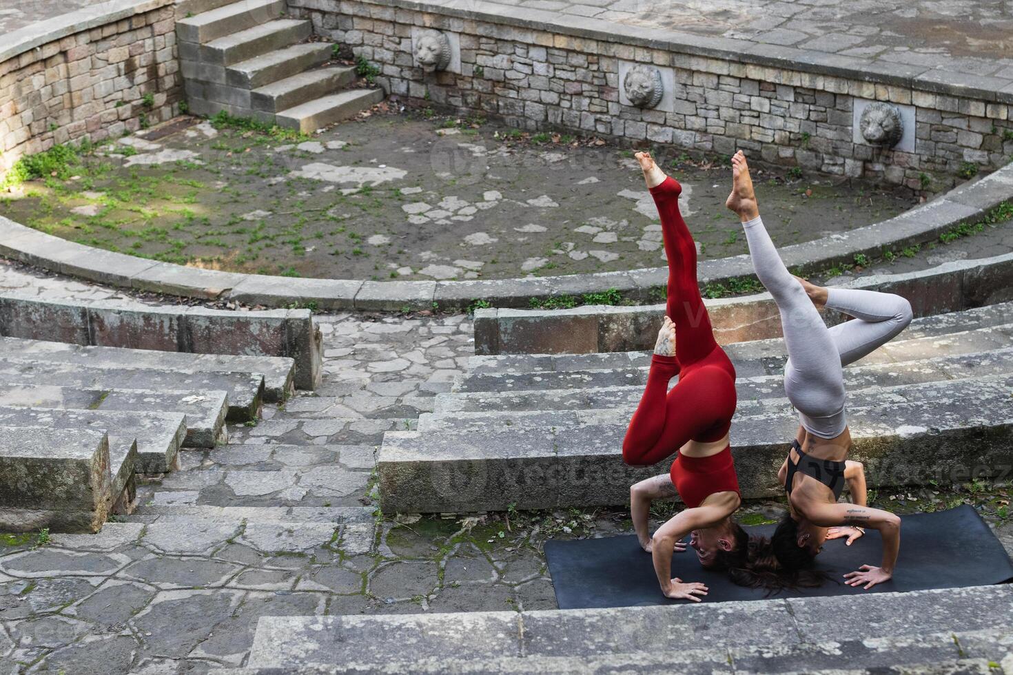 Two women doing yoga on a stone steps photo