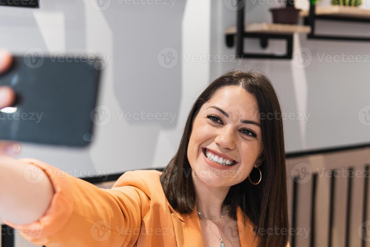 A woman taking a selfie with her smartphone photo