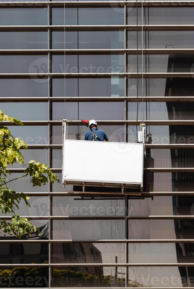 A man is cleaning a window on a building photo