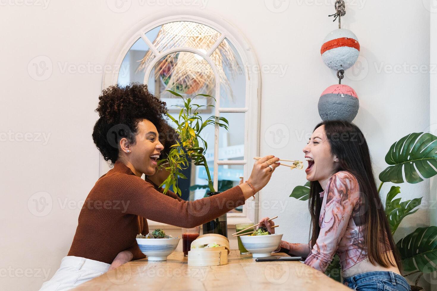 Two women eating at a table with a bowl of food photo