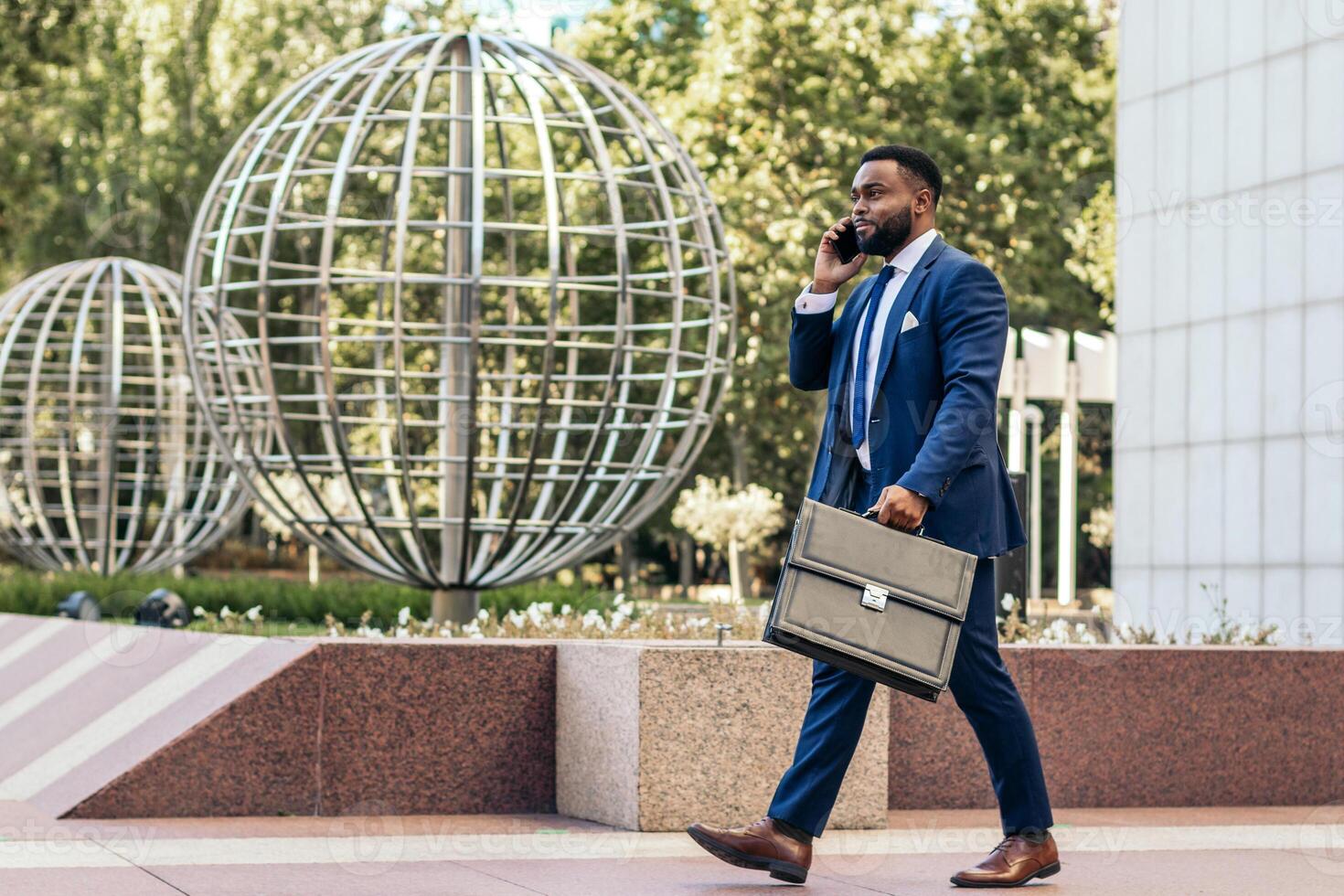 A man in a suit and tie walking with a briefcase photo