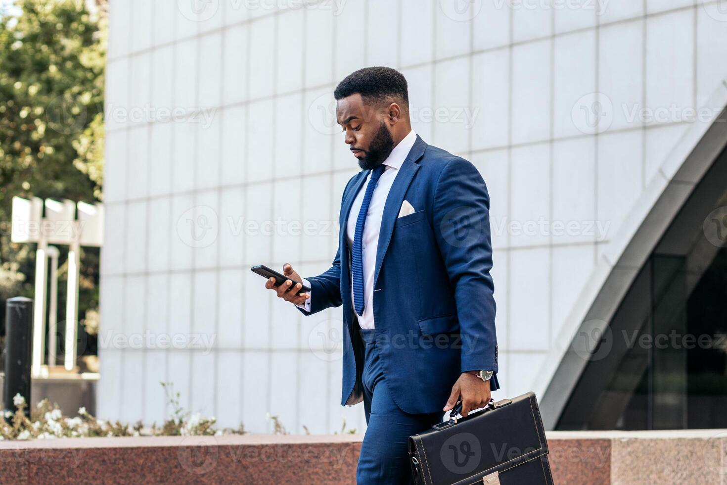 A man in a suit and tie is walking with his briefcase photo