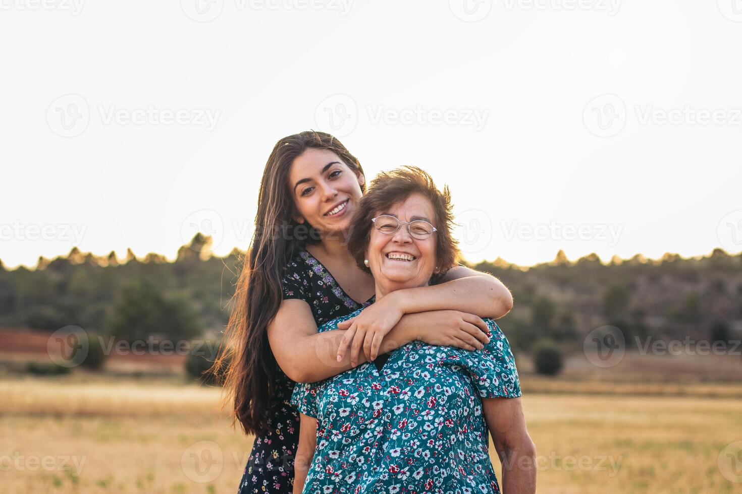 A woman hugging her grandmother in a field photo