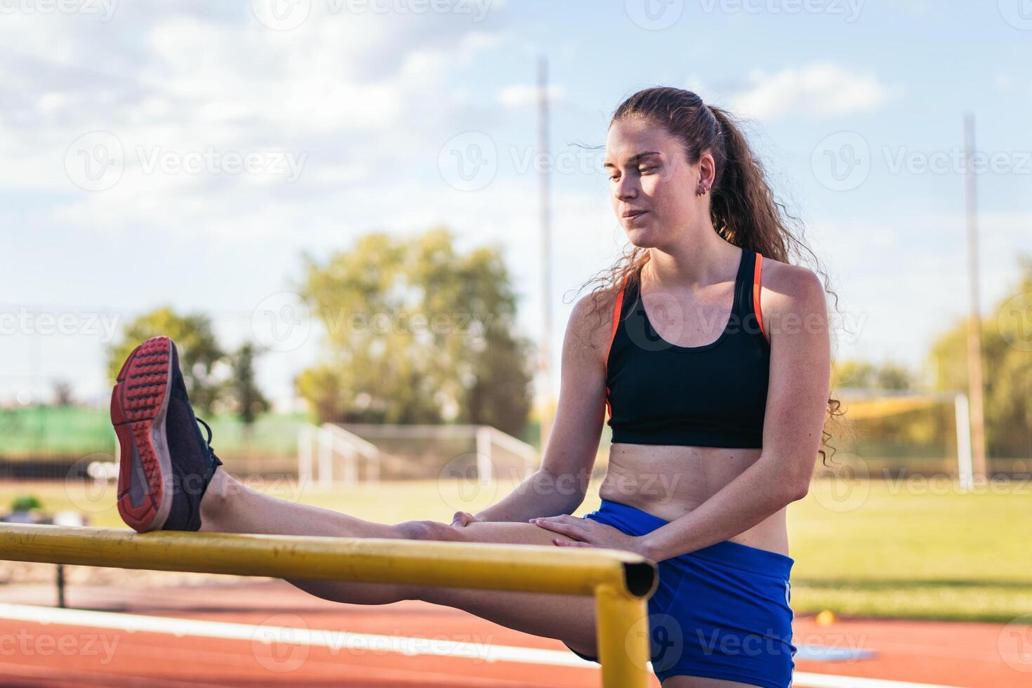 A woman is stretching on a track photo