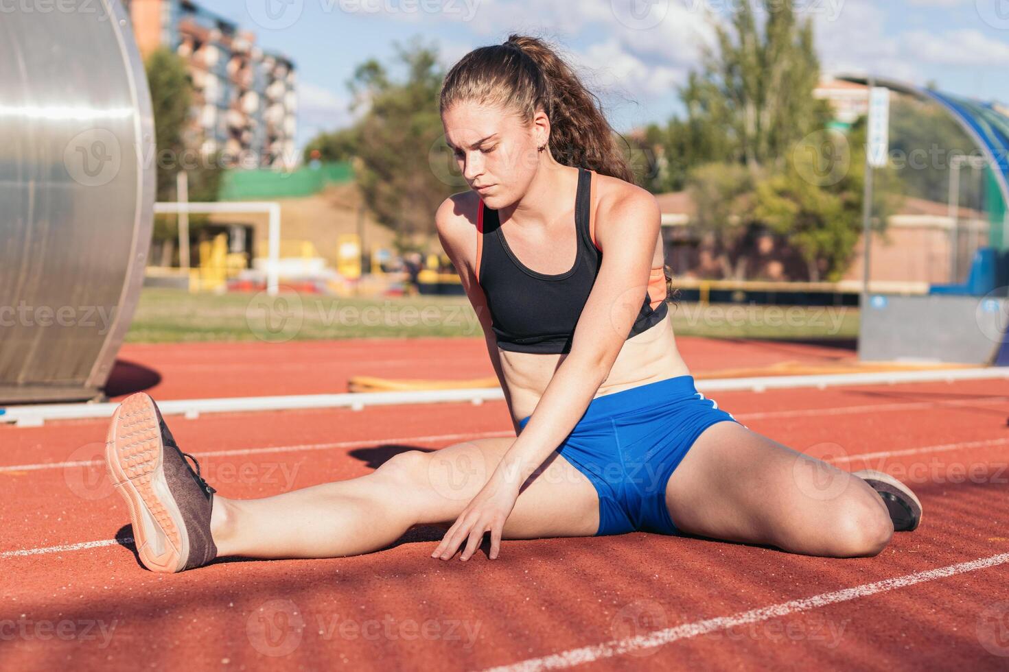 A woman stretching on a running track photo