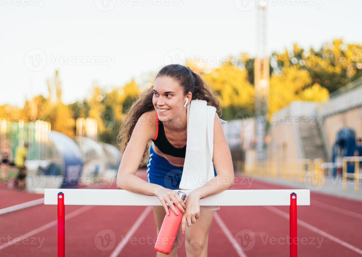 A woman is sitting on a hurdle and smiling photo