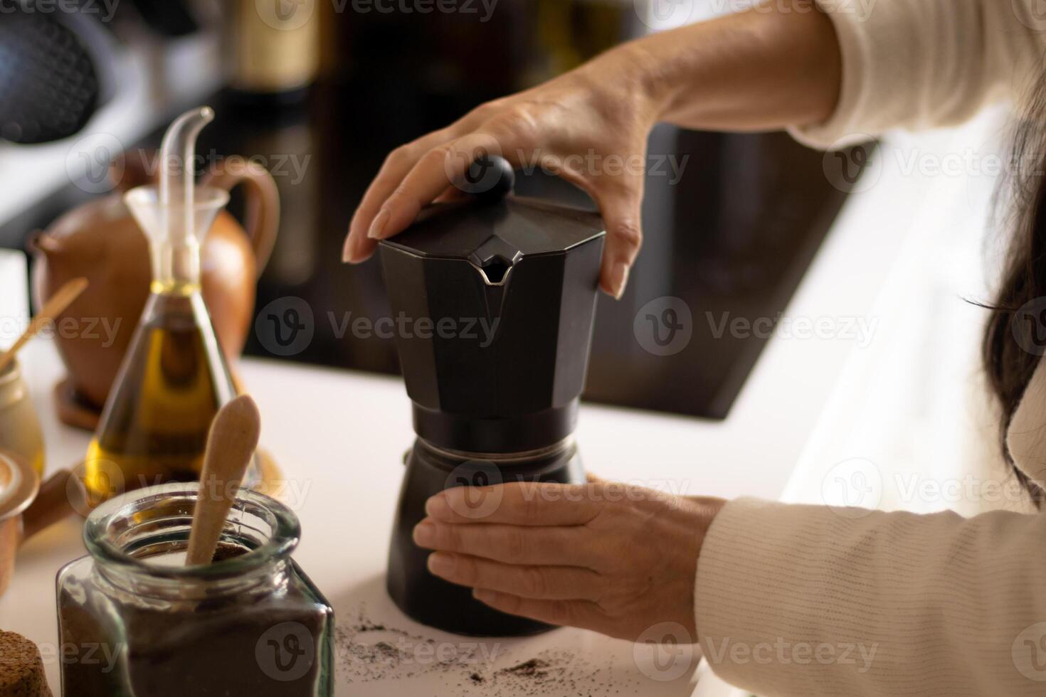A woman is pouring coffee into a coffee maker photo