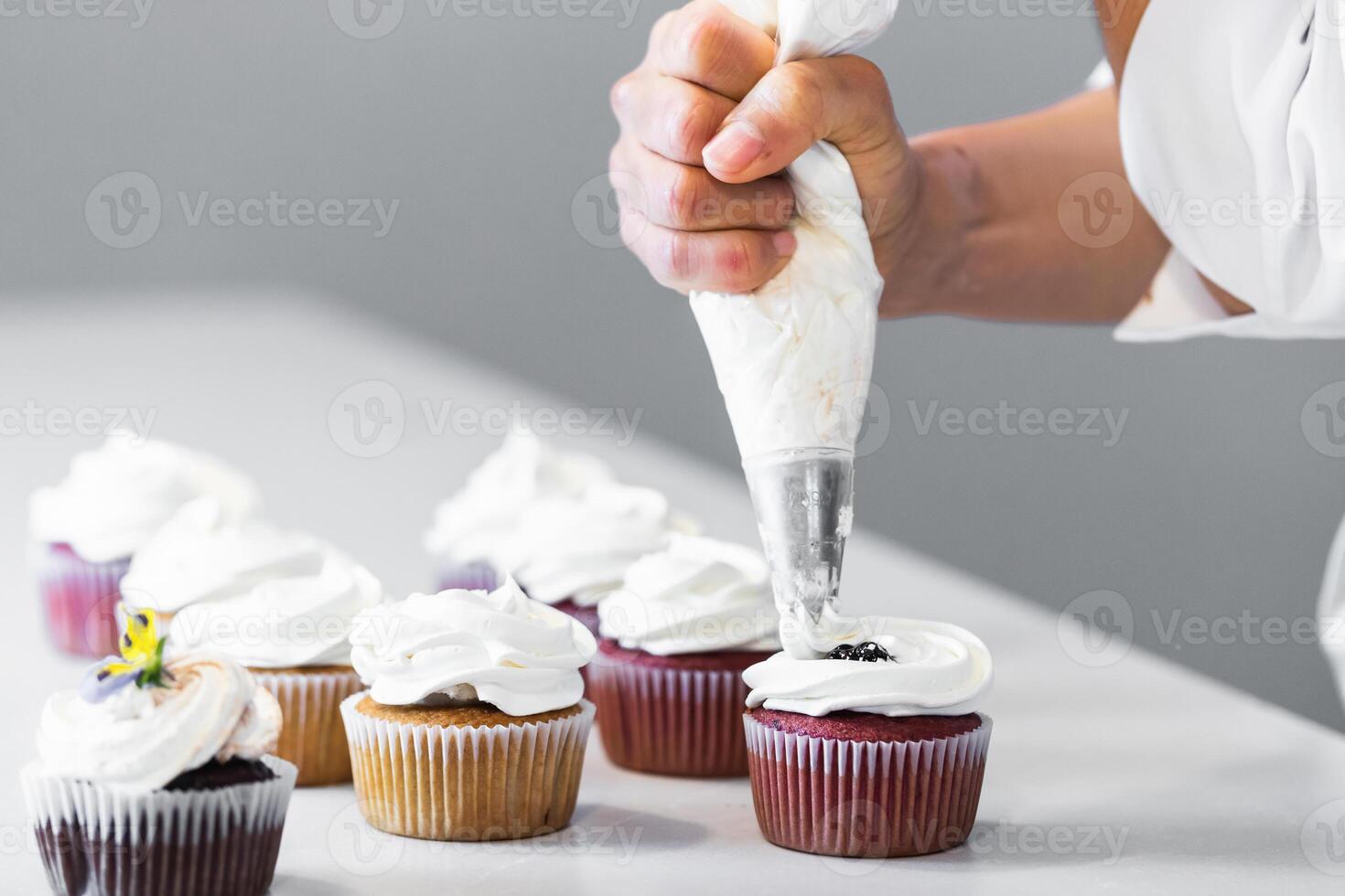 A person is decorating cupcakes with a knife photo