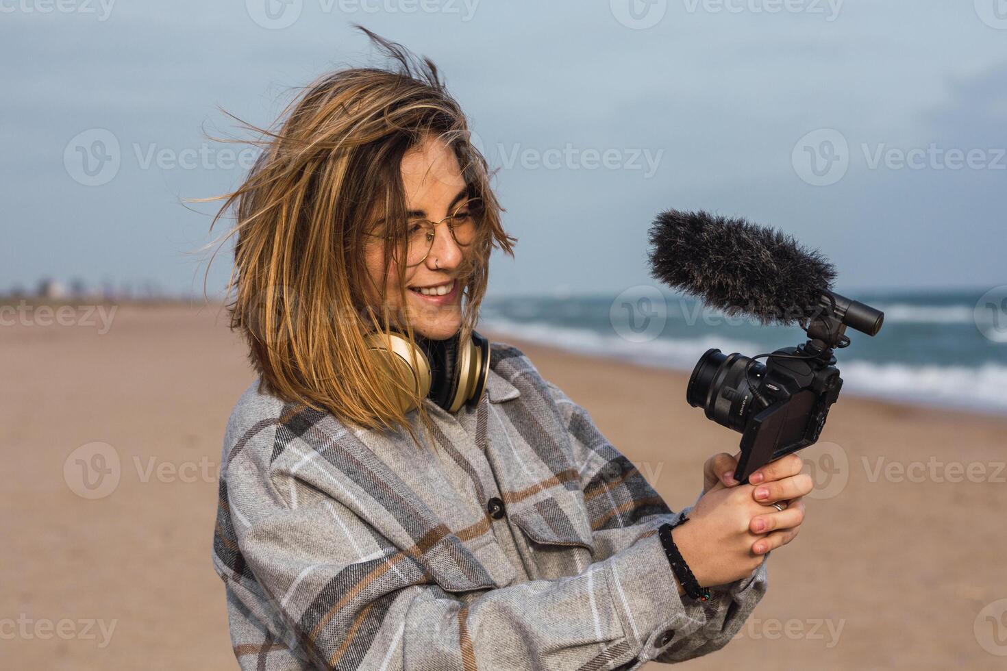 A woman holding a camera on the beach photo