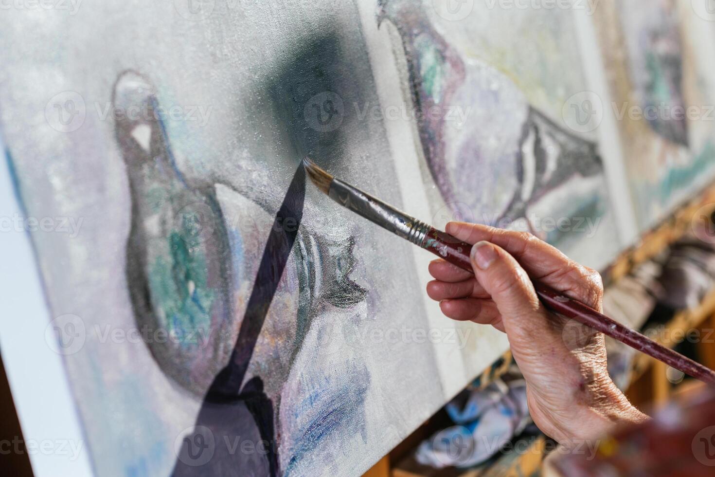 A person is painting a bird on a canvas photo