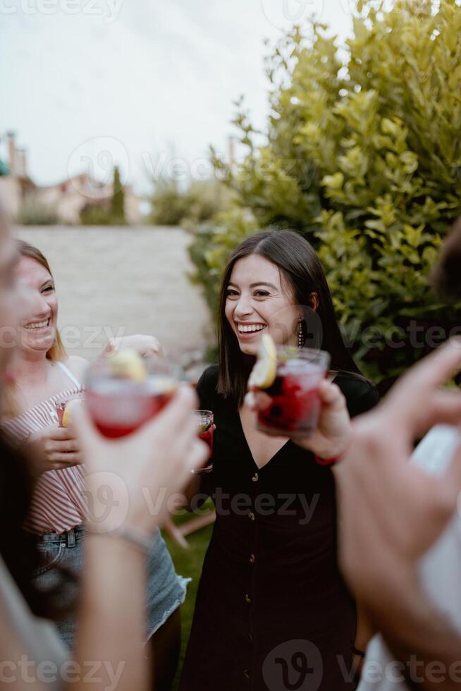 A group of people toasting with drinks photo