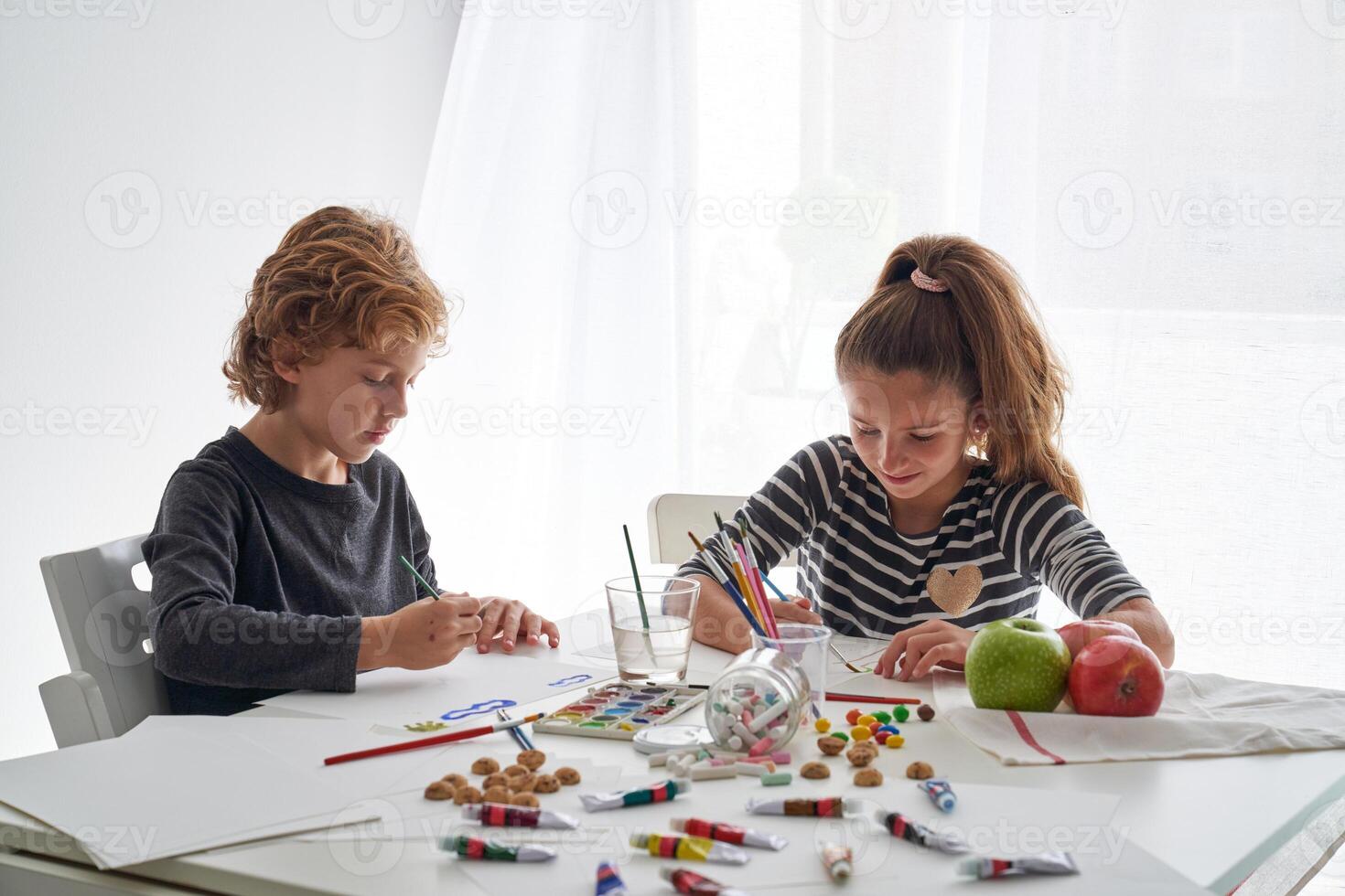 Two children at a table with crayons and markers photo