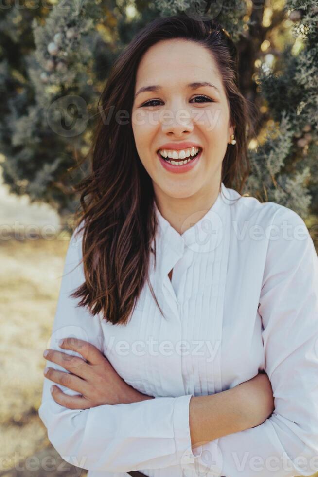 A woman smiling in front of a tree photo