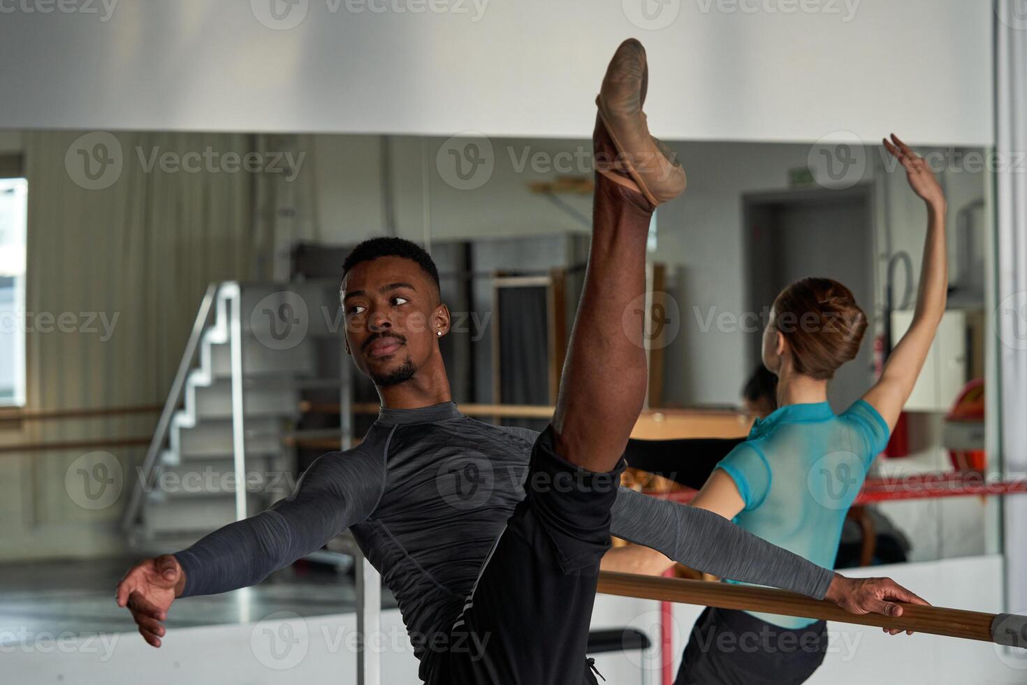 A man in a ballet class with his leg up photo