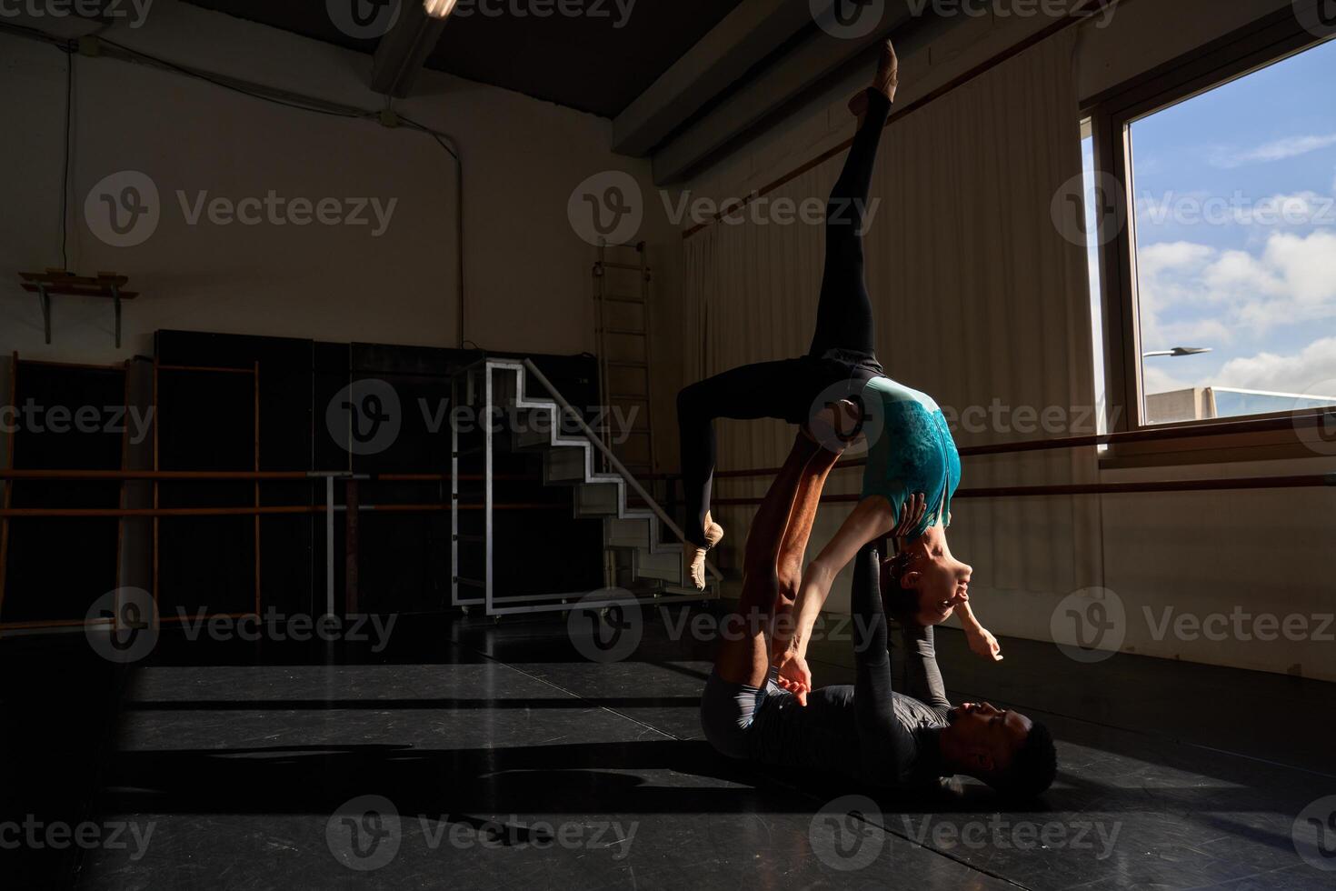 A man and woman doing a handstand in a dance studio photo